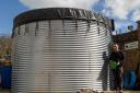 Mike Burks, managing director of The Gardens Group, in front of a 50,000-litre water tank, which was installed at Castle Gardens in Sherborne, Dorset in 2022 and connected to a Victorian plumbing system underneath the garden centre.