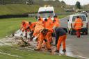 Castle Combe marshals work hard to clear the water but despite their efforts the race meeting was cancelled on Easter Monday. Pics EDP Photo News 52645 2.