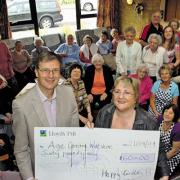 Day centre chairman Margaret White presents a cheque to Age Concern trustee Peter Baxter