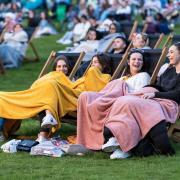 4 girls sitting with blankets at an outdoor cinema. Credit: Adventure Cinema