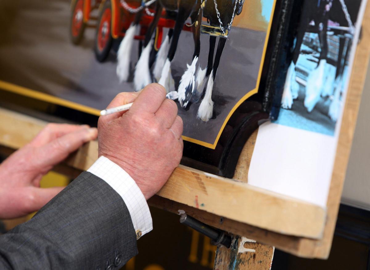 The Prince of Wales autographs a plaque during a visit to the Wadworth Brewery in Devizes. Picture: Steve Parsons/PA Wire