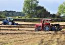 The driver in the foreground adjusts his settings in a ploughing match at Manor Farm