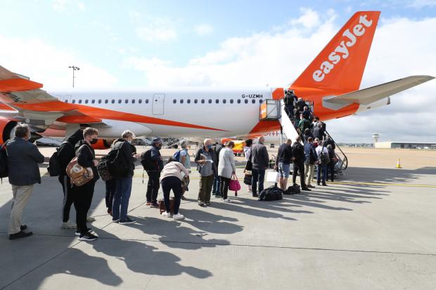 The Wiltshire Gazette and Herald: People queue to board an EasyJet plane. (PA)