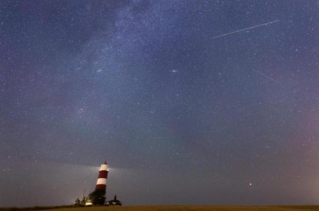 A meteor during the Perseid meteor shower seen over Happisburgh lighthouse, Norfolk. Sky gazers are set to be treated to a light display next week as Earth passes through debris left behind by a comet. Issue date: Friday August 6, 2021. Credit: PA
