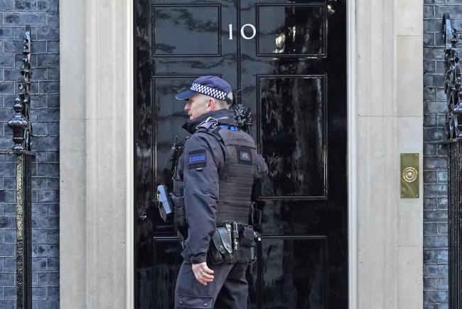 A police officer knocks on the door of the Prime Minister's official residence in Downing Street, Westminster, London, as public anger continues following the leak on Monday of an email from Boris Johnson's principal private secretary, Martin