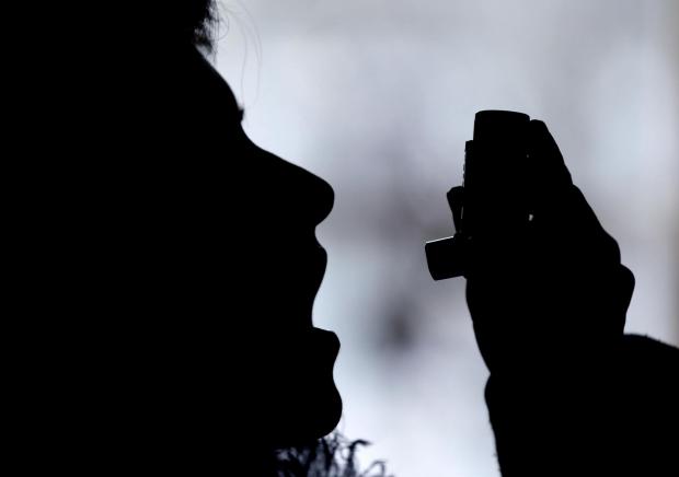 The Wiltshire Gazette and Herald: Silhouette of a person using an inhaler. Credit: Canva