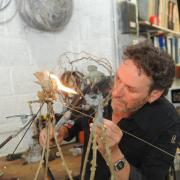Busy  fabricating his latest sculpture   silver soldering  a bronze bird  Patrick Haines Photo by Trevor Porter