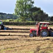 The driver in the foreground adjusts his settings in a ploughing match at Manor Farm