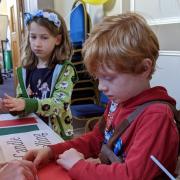 Children learn how to roll candles at the Wiltshire Bee & Honey Day