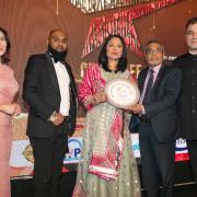 Arju Miah MBE and Ahkik Miah receiving the award from Rushanara Ali MP and Lord Bilimoria
