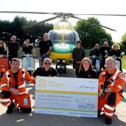 Jay Webb and Sharon Todd present a cheque to Fred Thompson and Keith Mills of Wiltshire Air Ambulance watched by scooter club members. Picture by Siobhan Boyle